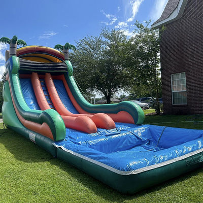 Commerciële opblaasbare waterslide met dubbele baan en tropisch palmboomthema