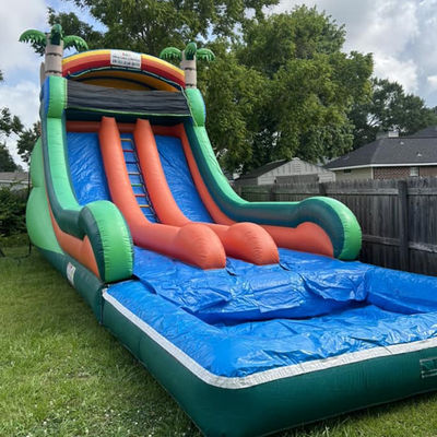 Commerciële opblaasbare waterslide met dubbele baan en tropisch palmboomthema