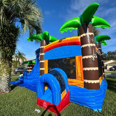 Kinderen speeltuin opblaasbaar springhuis met glijbaan en palmboom